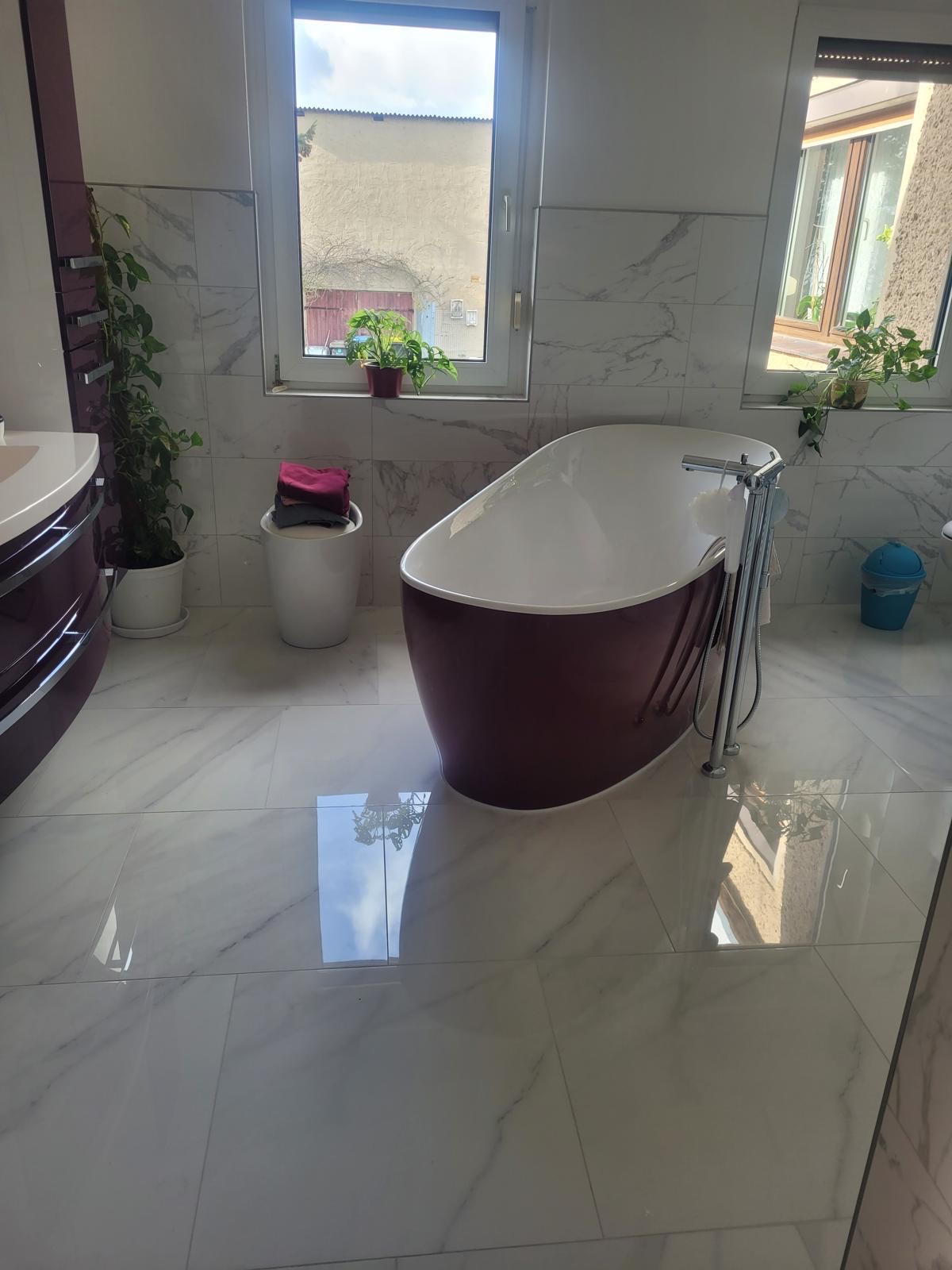 Ein stilvolles Badezimmer mit freistehender Badewanne und Marmorfliesen.